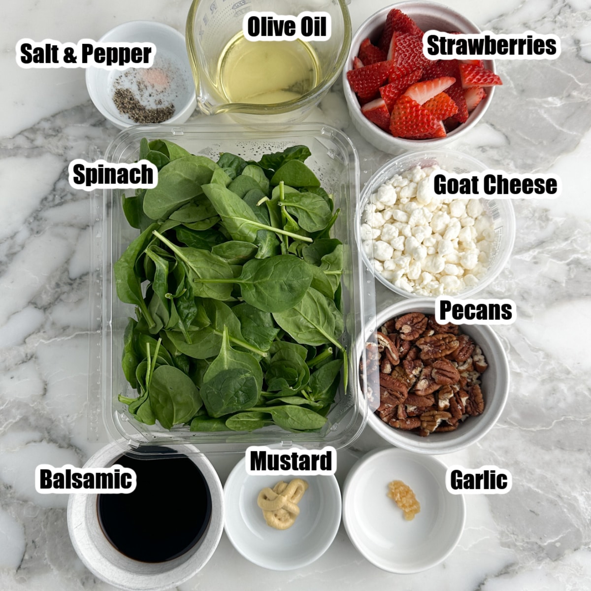 Spinach, bowl of vinegar, mustard, garlic, strawberries, cheese, and pecans. 