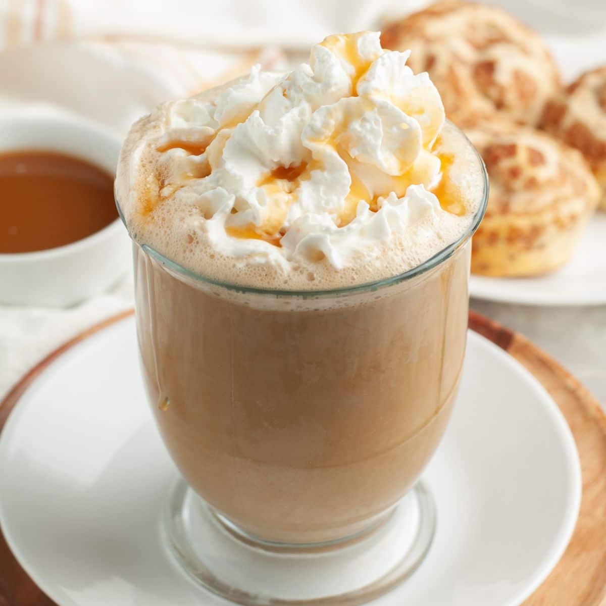 Mug of caramel latte topped with whipped cream. 
