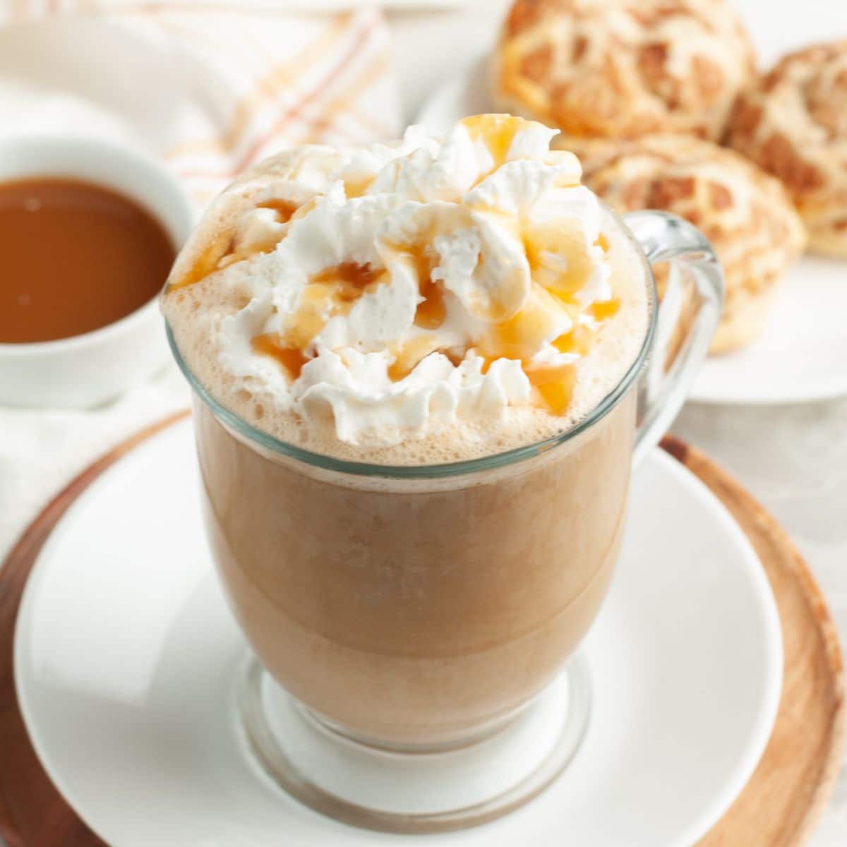 Caramel latte in a mug topped with whipped cream. 
