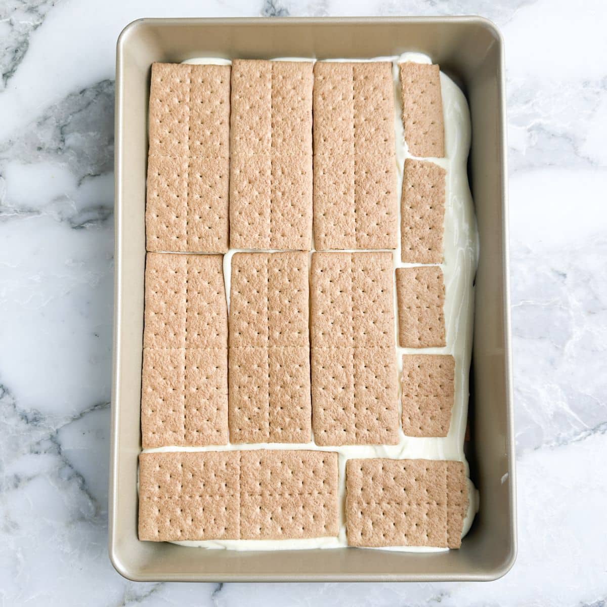 Baking dish with pudding topped with graham crackers. 