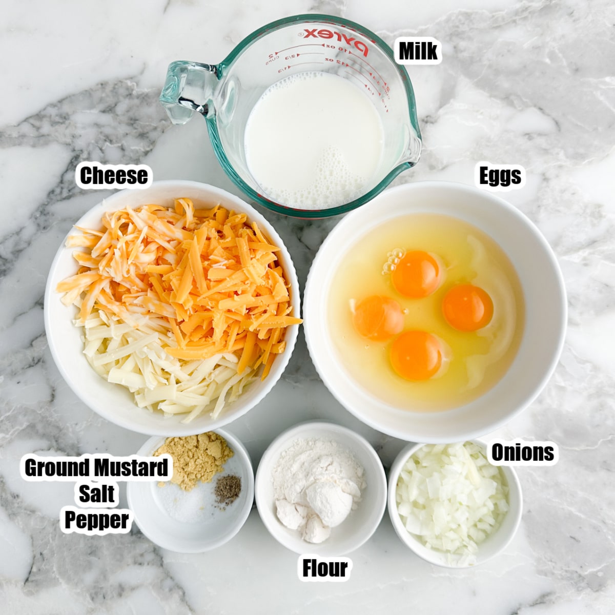 Bowl of eggs, shredded cheese, milk, seasonings, diced onions, and flour.