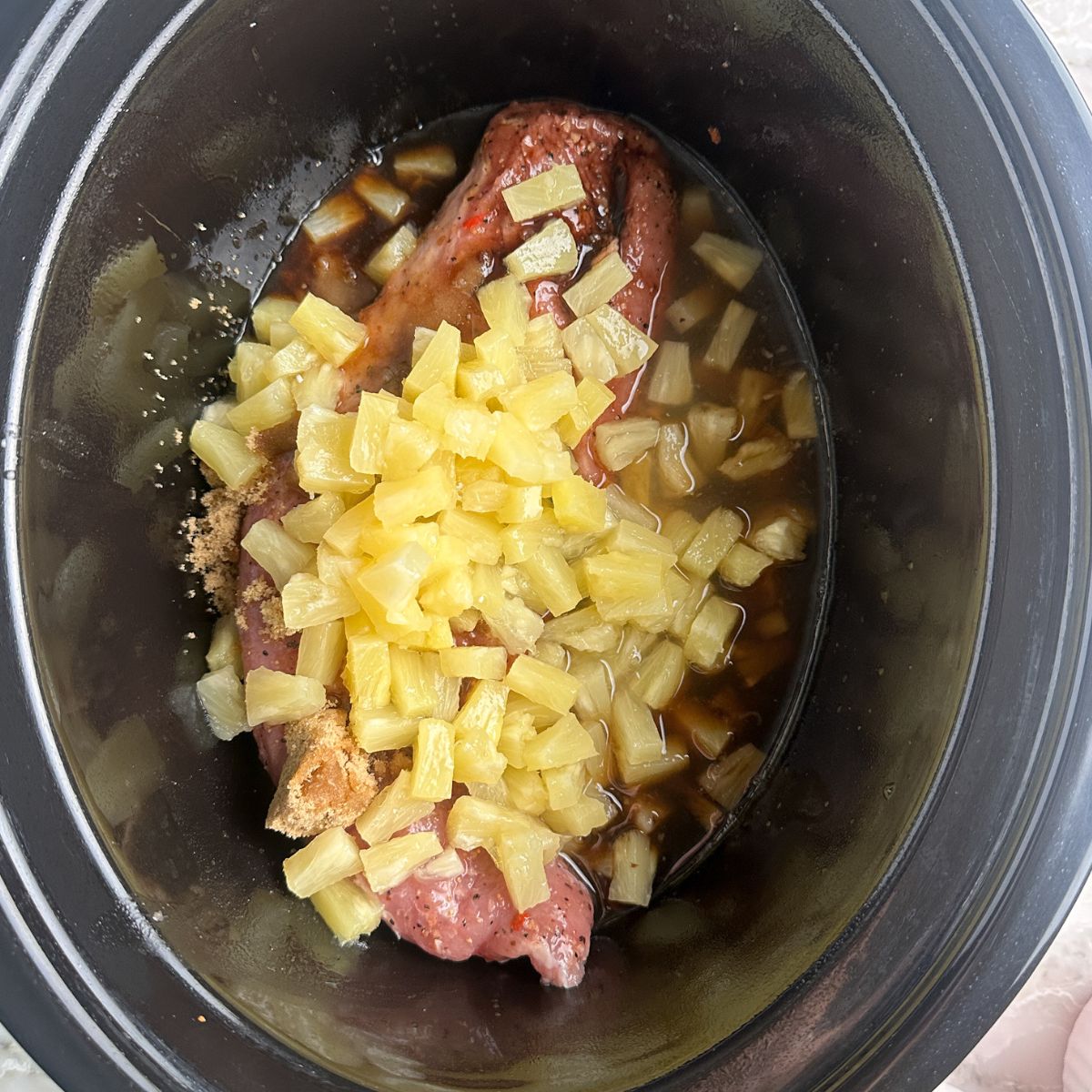 Slow cooker with pork tenderloin and pineapple. 