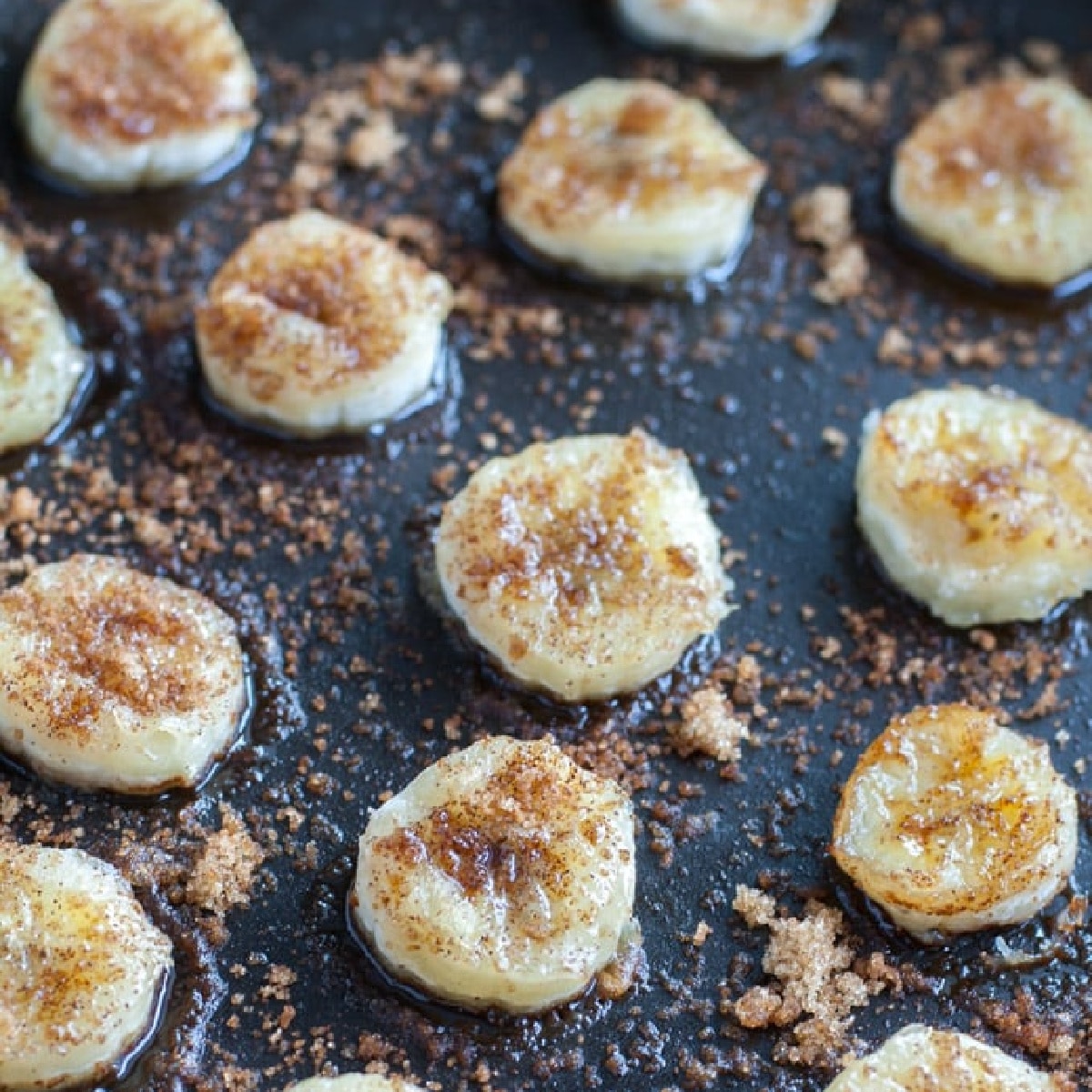 Skillet with sliced bananas covered in brown sugar.