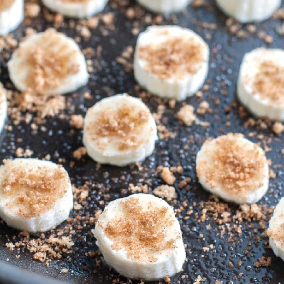 Skillet with sliced bananas topped with brown sugar. 