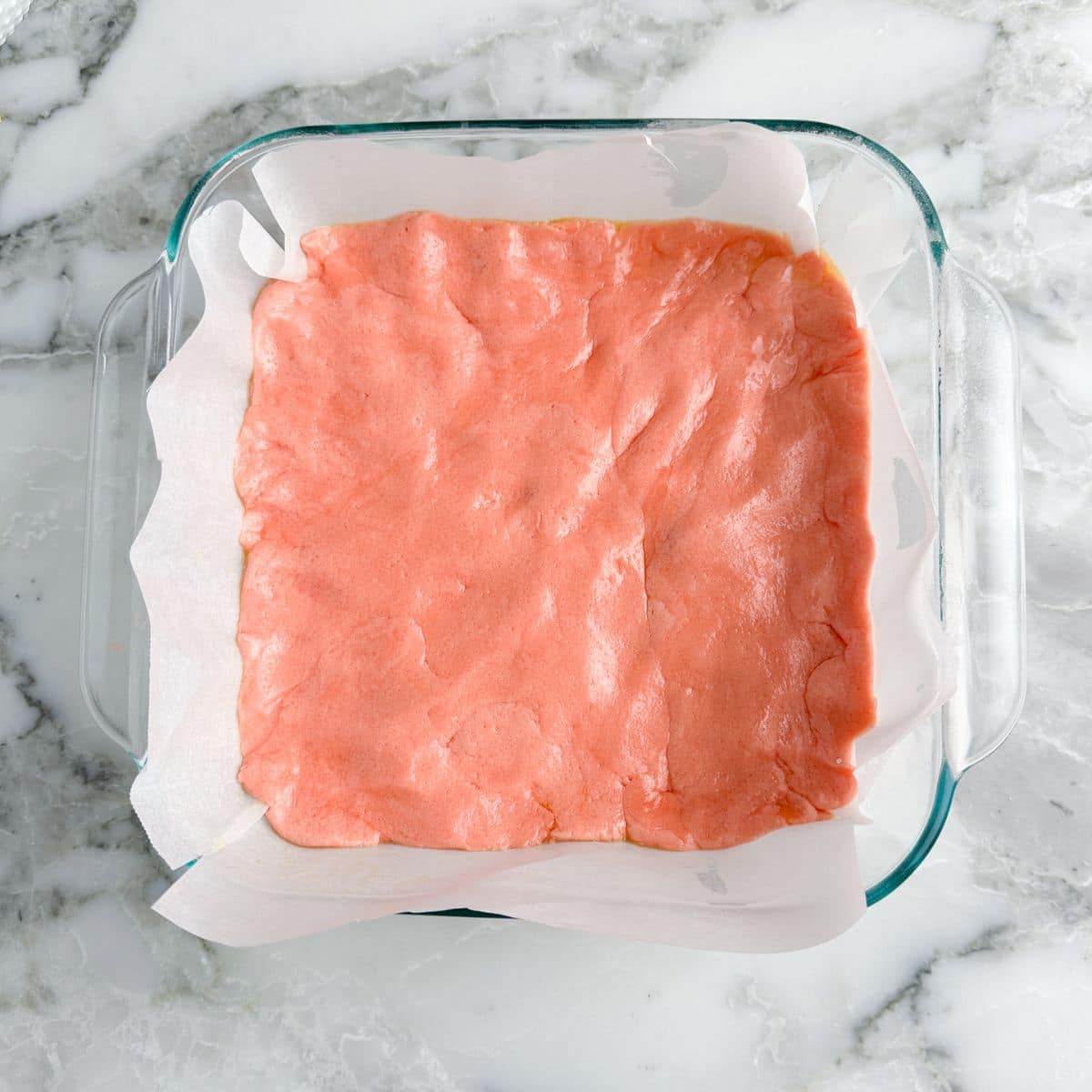 Baking dish with strawberry bar batter.