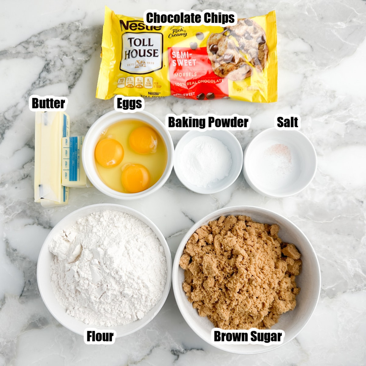 Bag of chocolate chips, bowl of brown sugar, flour, butter, eggs, and baking powder. 