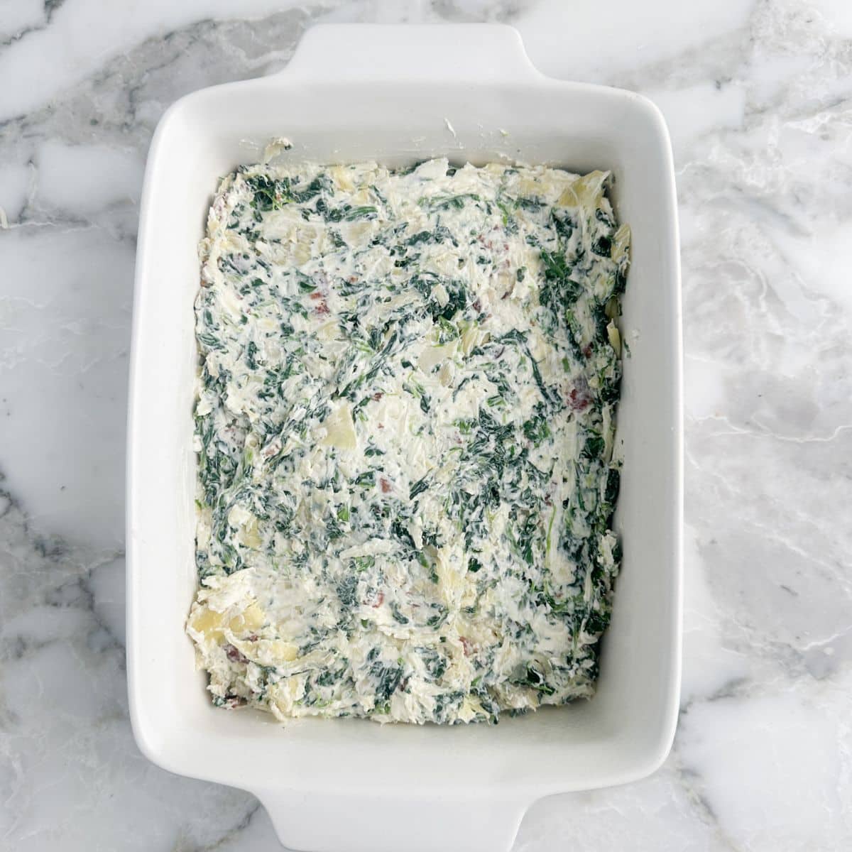 Baking dish filled with spinach artichoke dip.