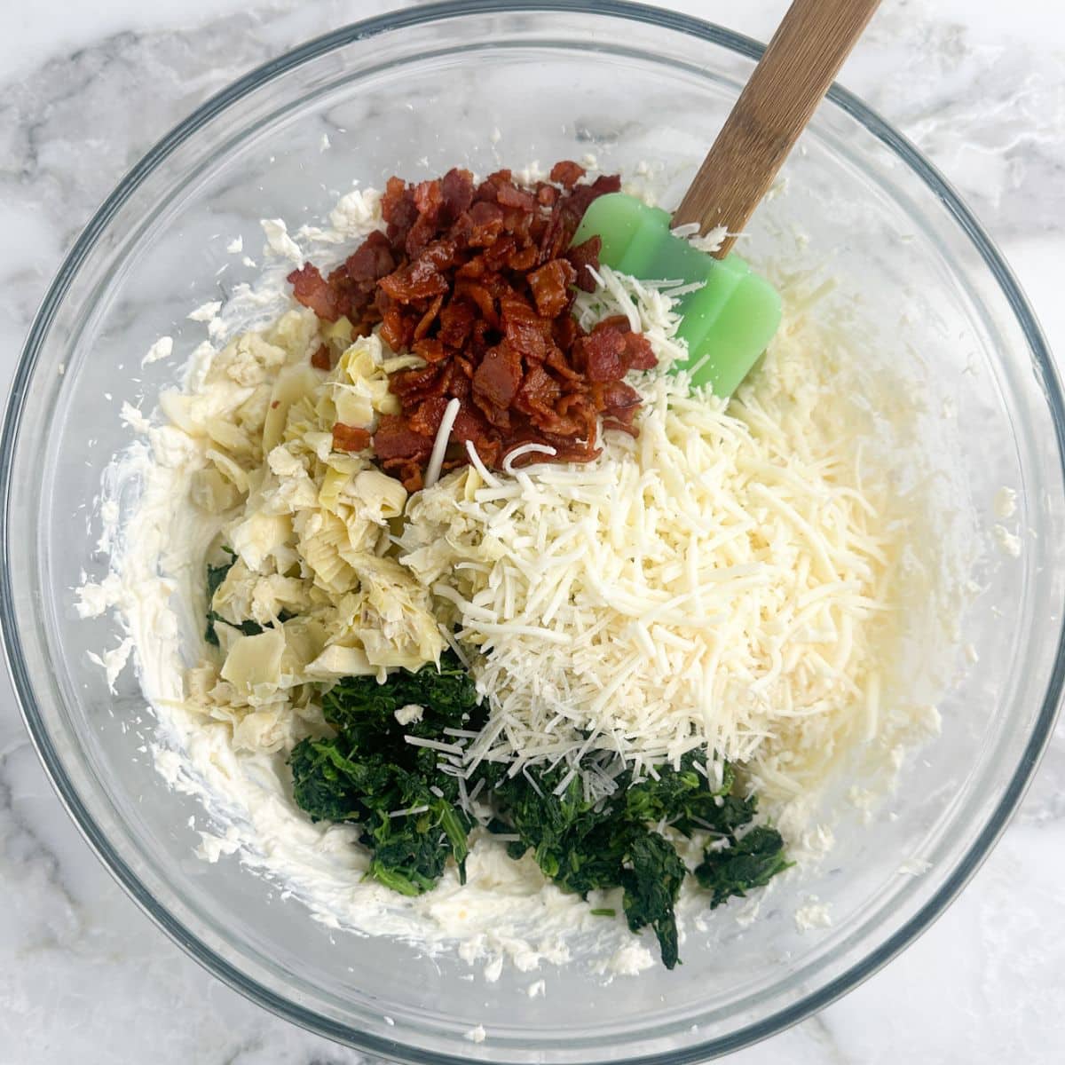 Bowl with cream cheese, cheese, spinach, artichokes, and bacon.