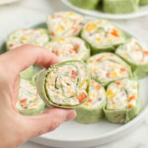 Hand holding vegetable pinwheels.