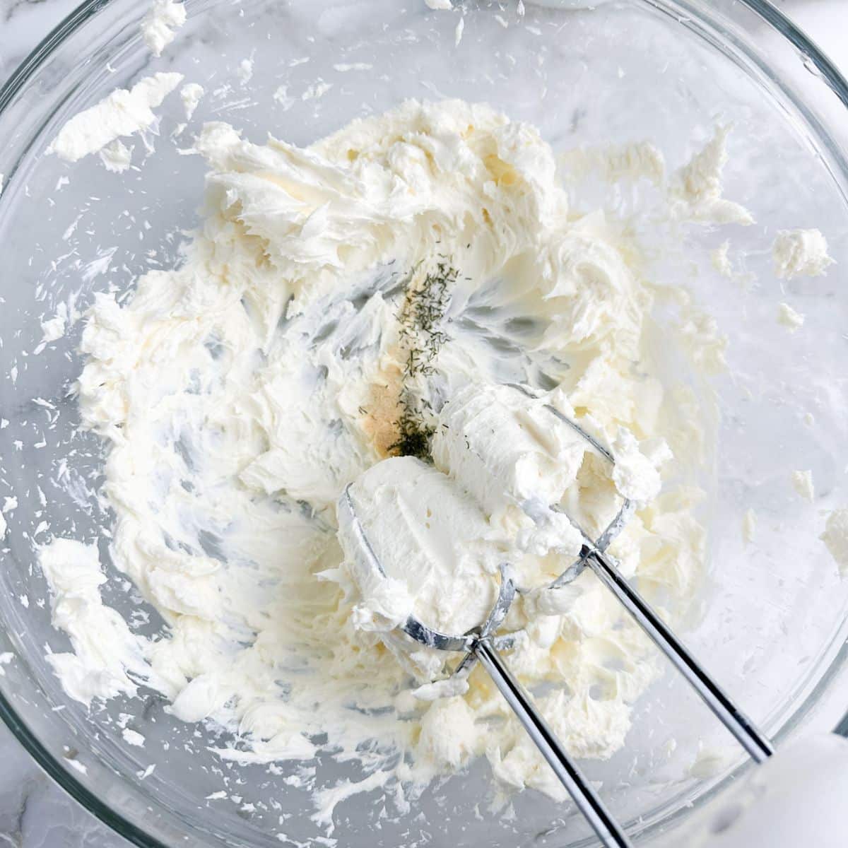 Bowl of whipped cream cheese with a mixer.