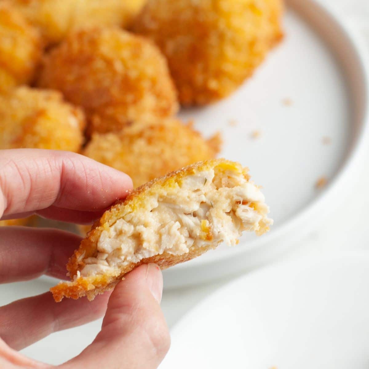 Hand holding a chicken croquette.