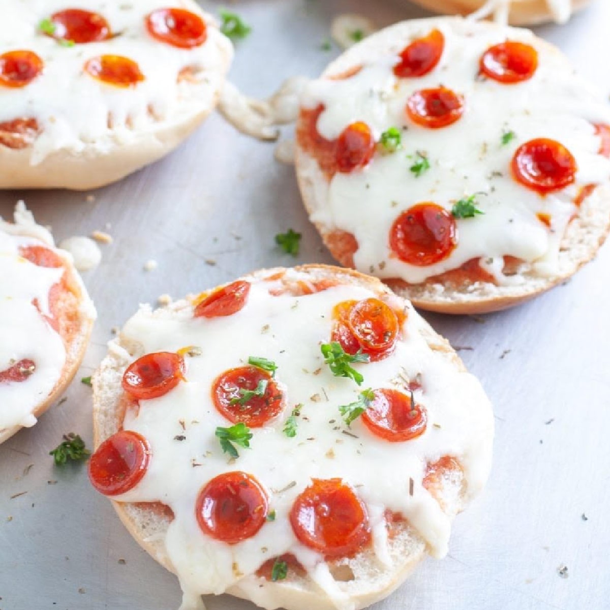 Pepperoni pizza bagels on a pan.