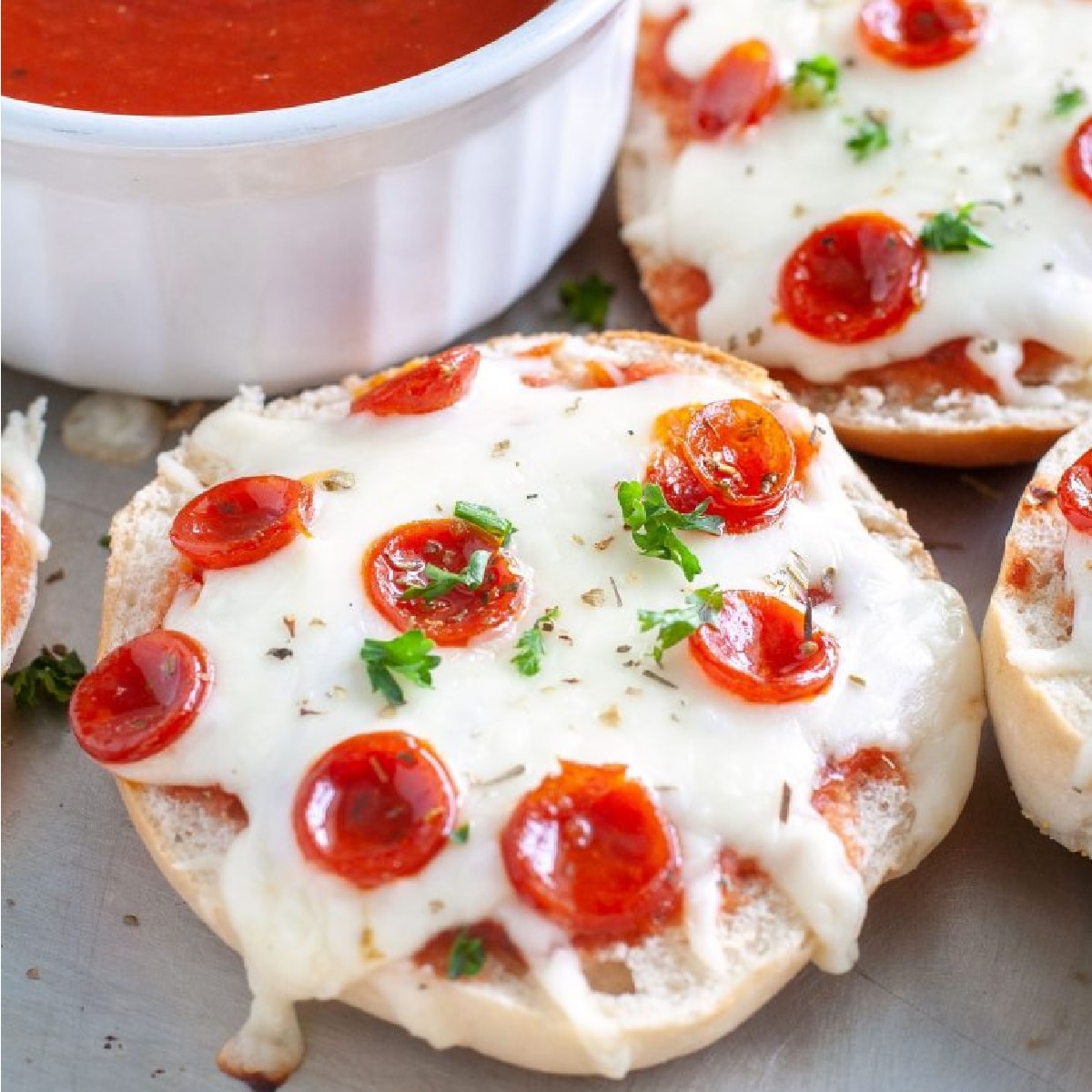 Pepperoni pizza bagels on a plate.