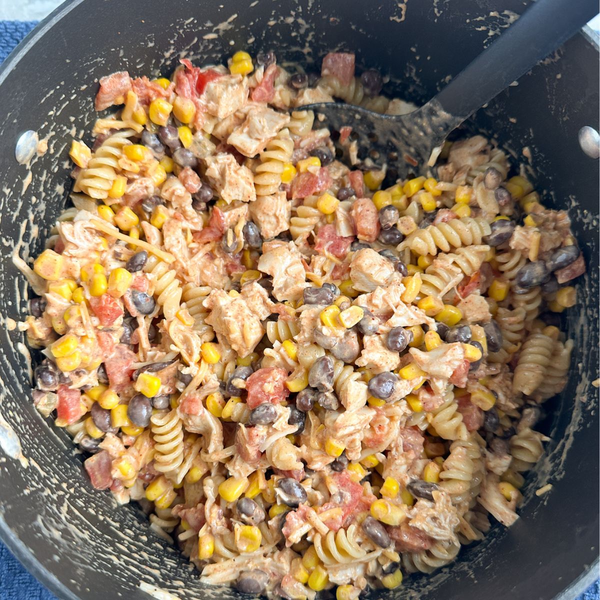 Pot with a pasta, chicken, and bean mixture.