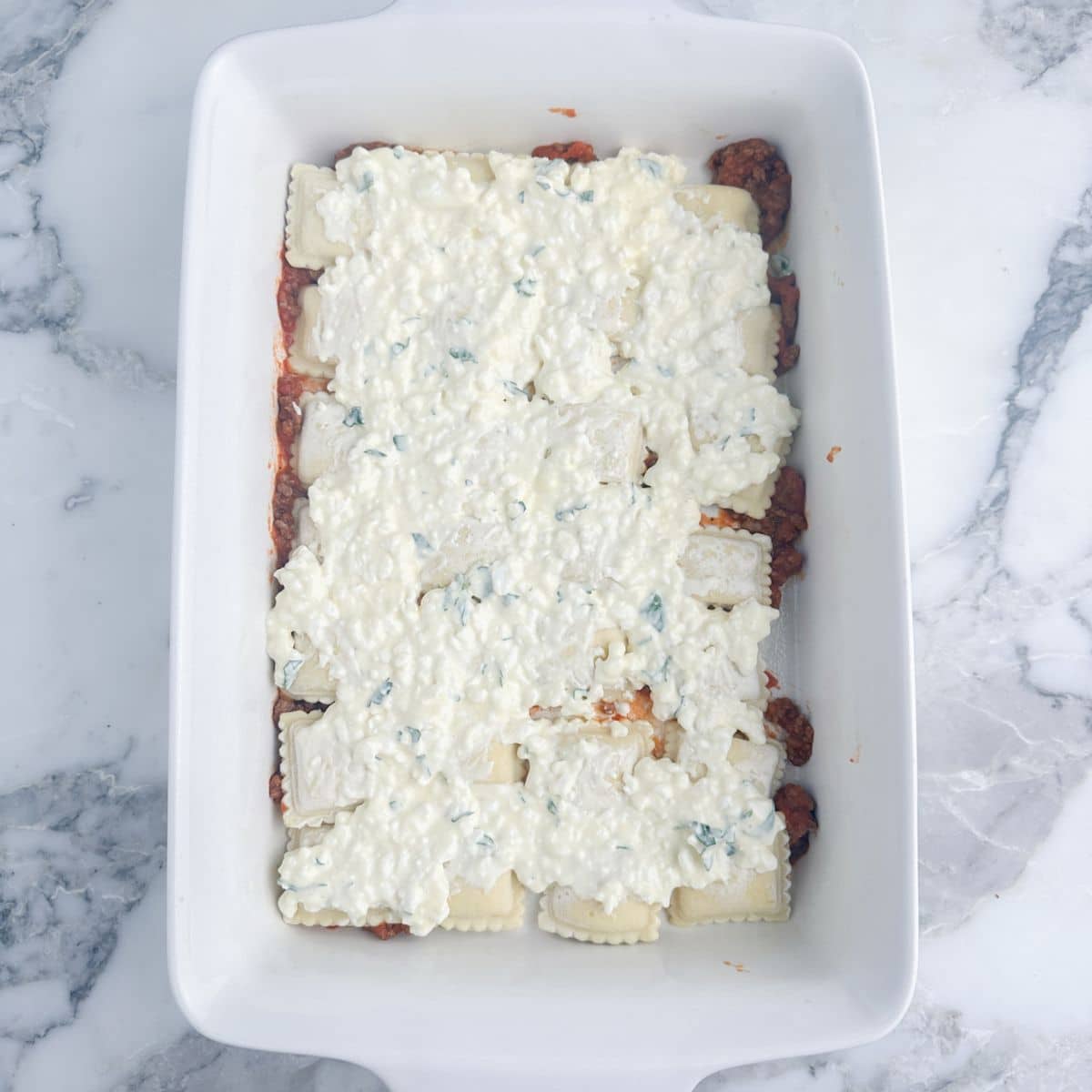 Baking dish with ravioli and cottage cheese. 