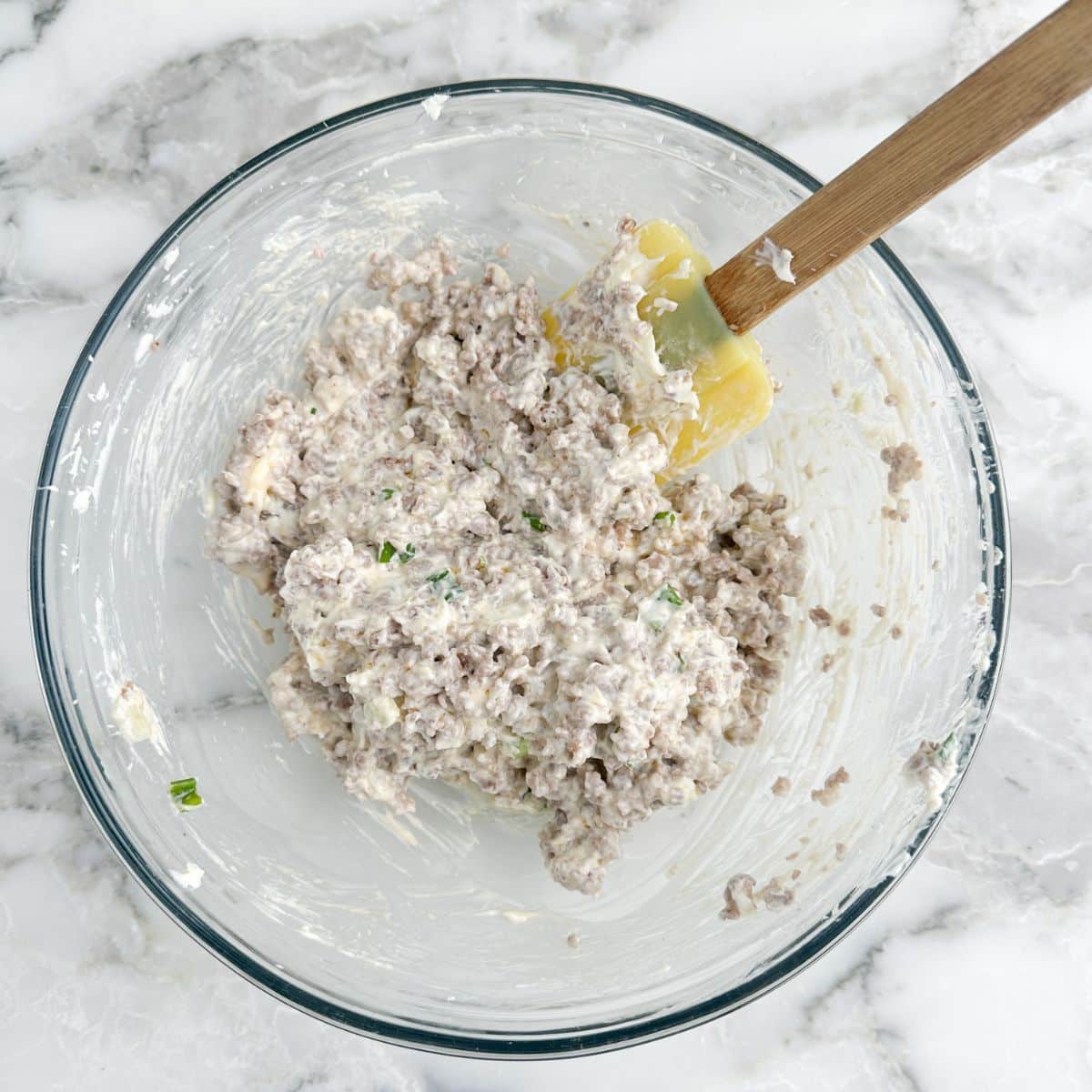 Bowl with cream cheese mixed with sausage.