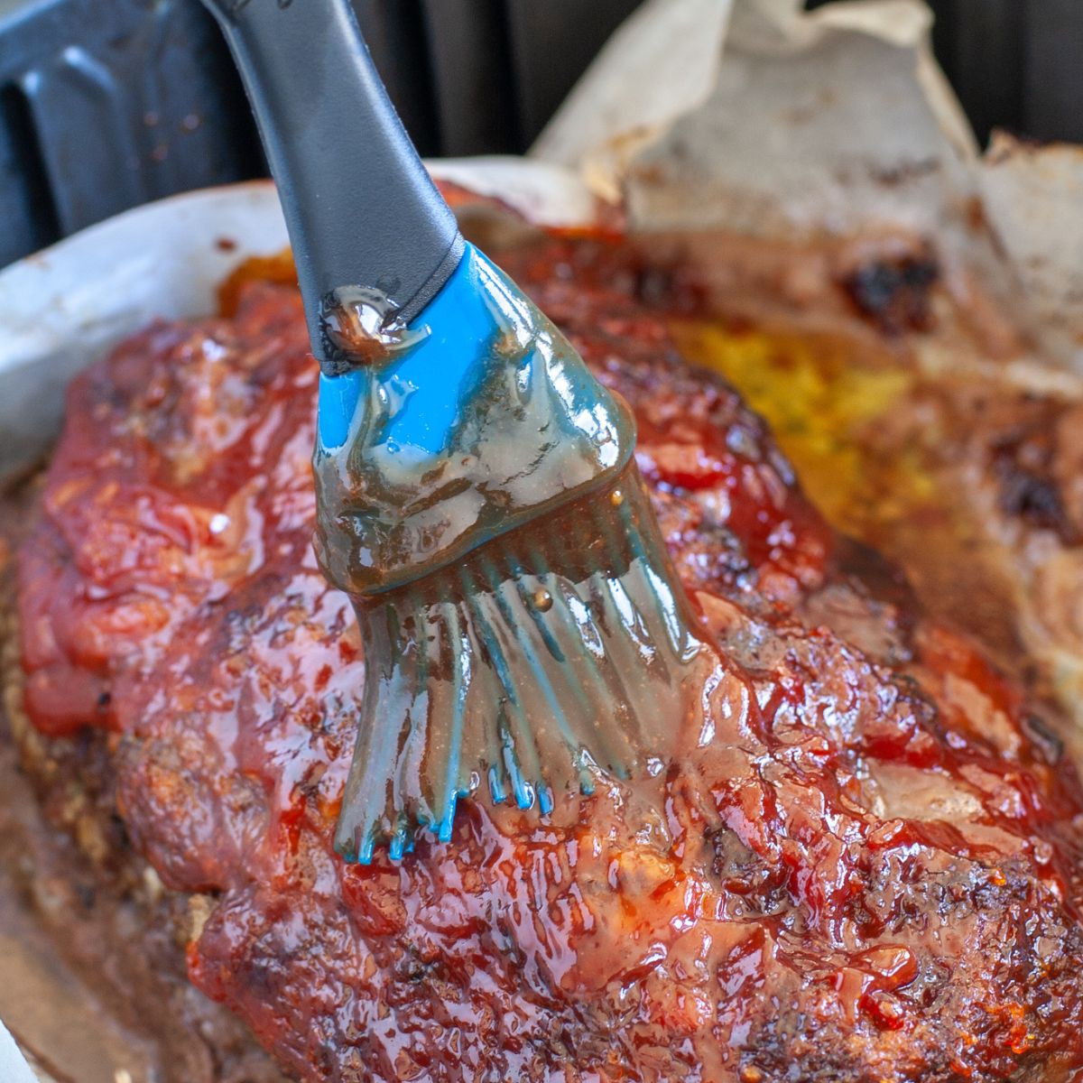 Brushing on meatloaf sauce on air fryer meatloaf. 