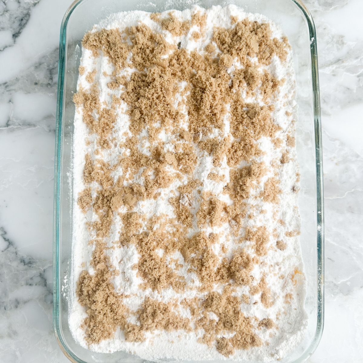 Casserole dish with cake mix and brown sugar. 