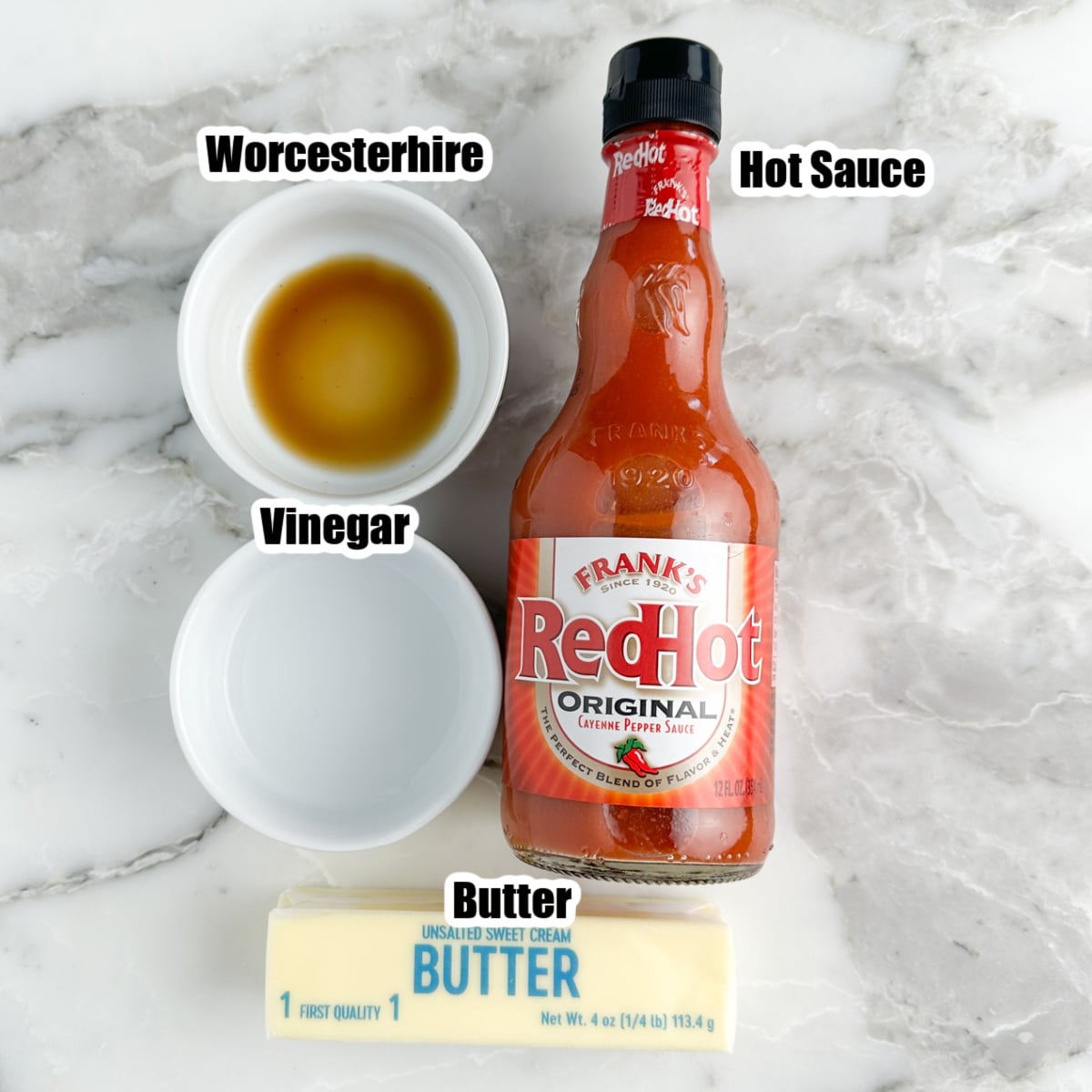 Bottle of hot sauce, bowl of vinegar, worcestershire, and butter. 