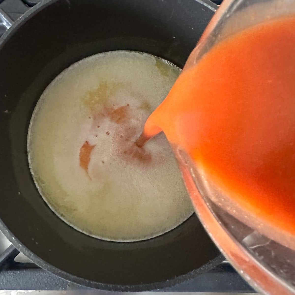 Hot sauce pouring into melted butter. 