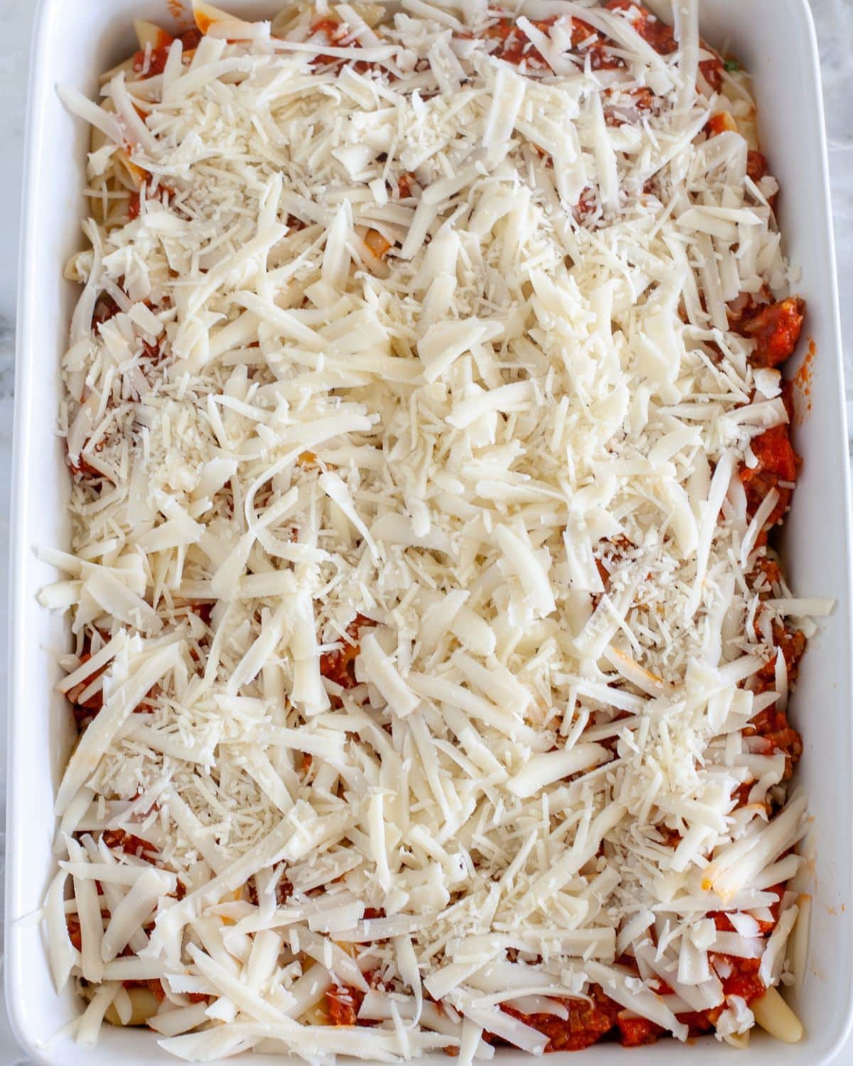 Pasta with red sauce and cheese in a baking dish. 