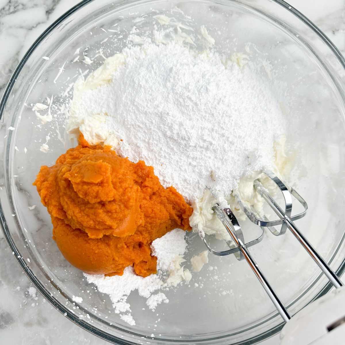 Bowl with cream cheese, canned pumpkin, and powdered sugar. 