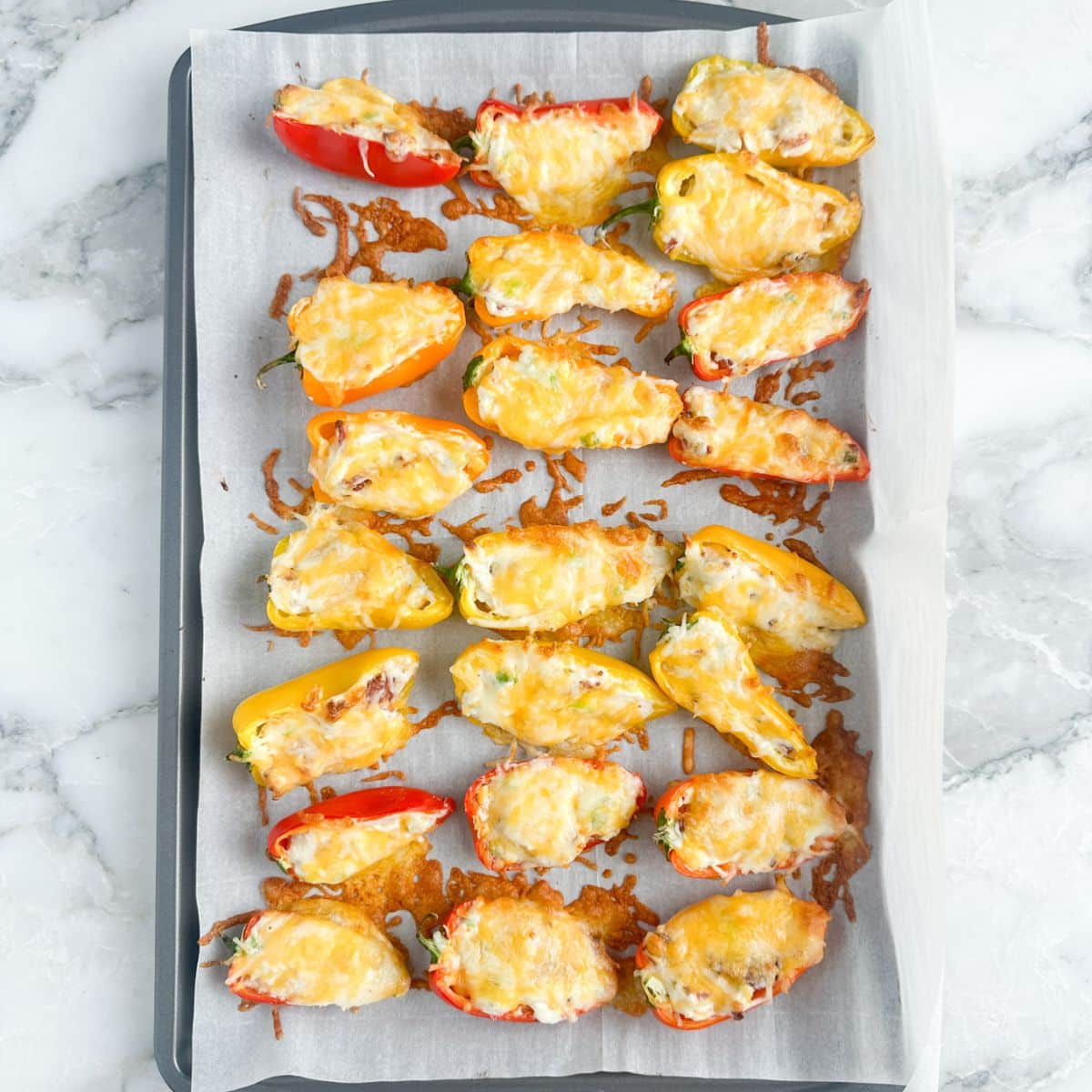 Cream cheese stuffed peppers on a baking sheet. 