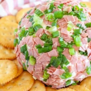 Chipped beef cheese ball on a plate with crackers.