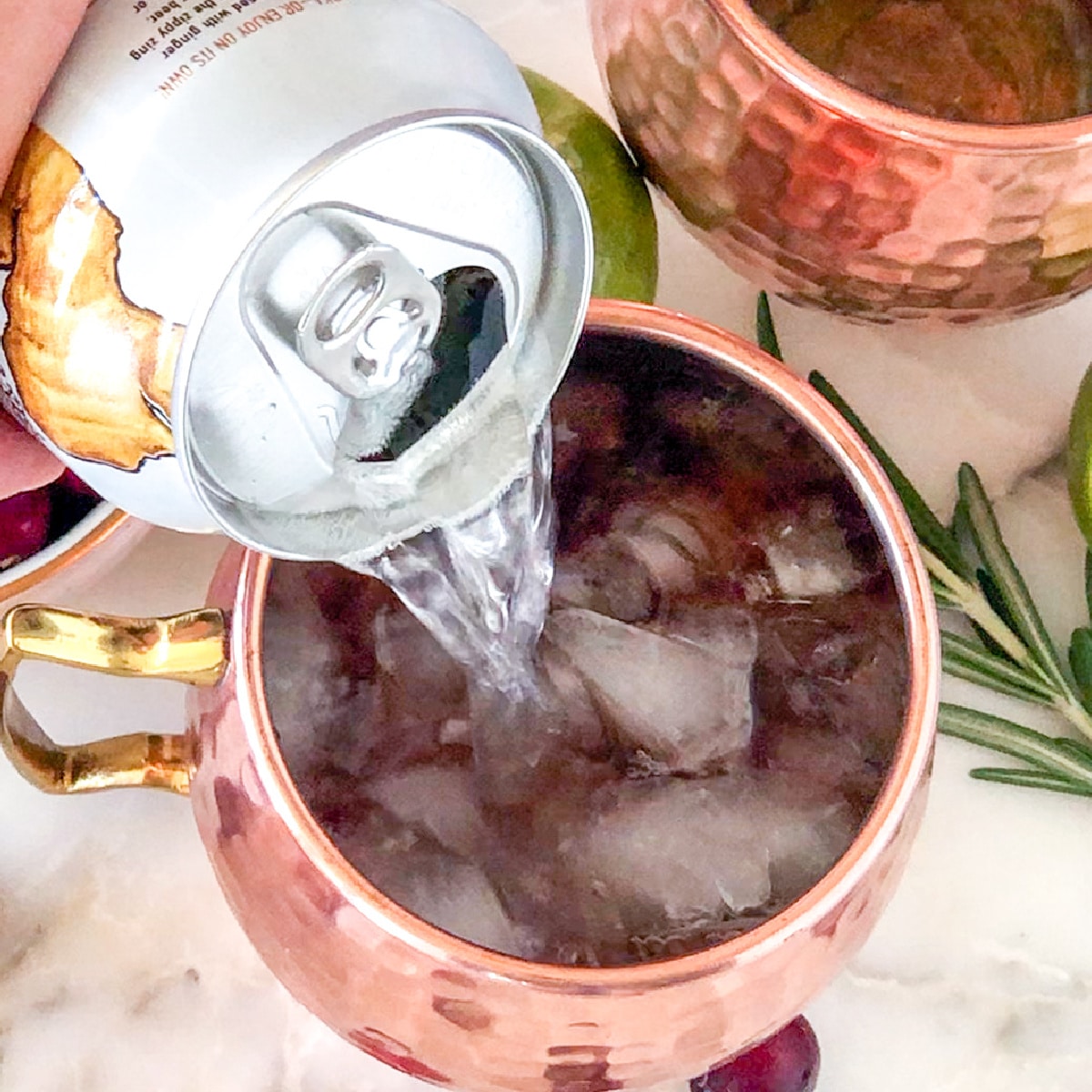 Ginger beer pouring into glass with ice.