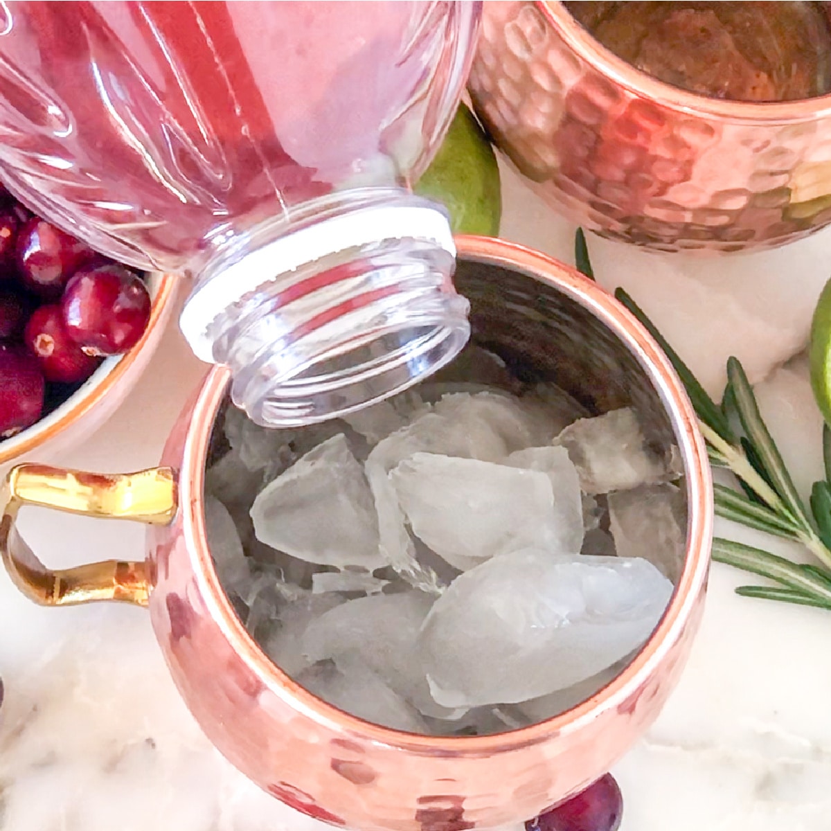 Cranberry juice pouring into a glass with ice.