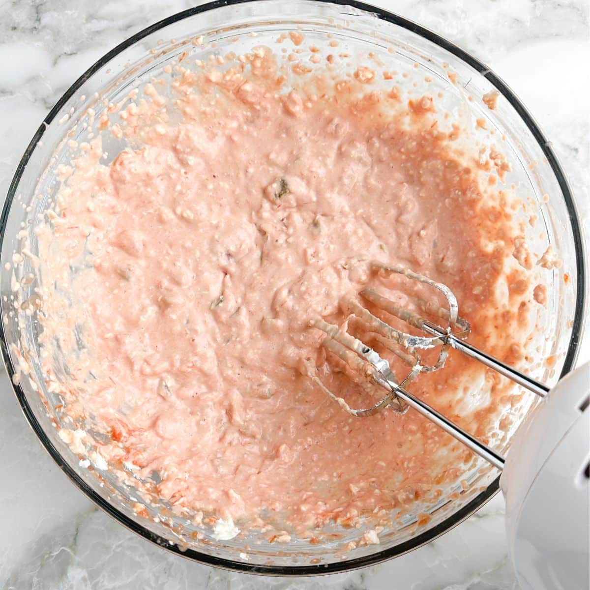 Bowl of cream cheese salsa dip with mixer.