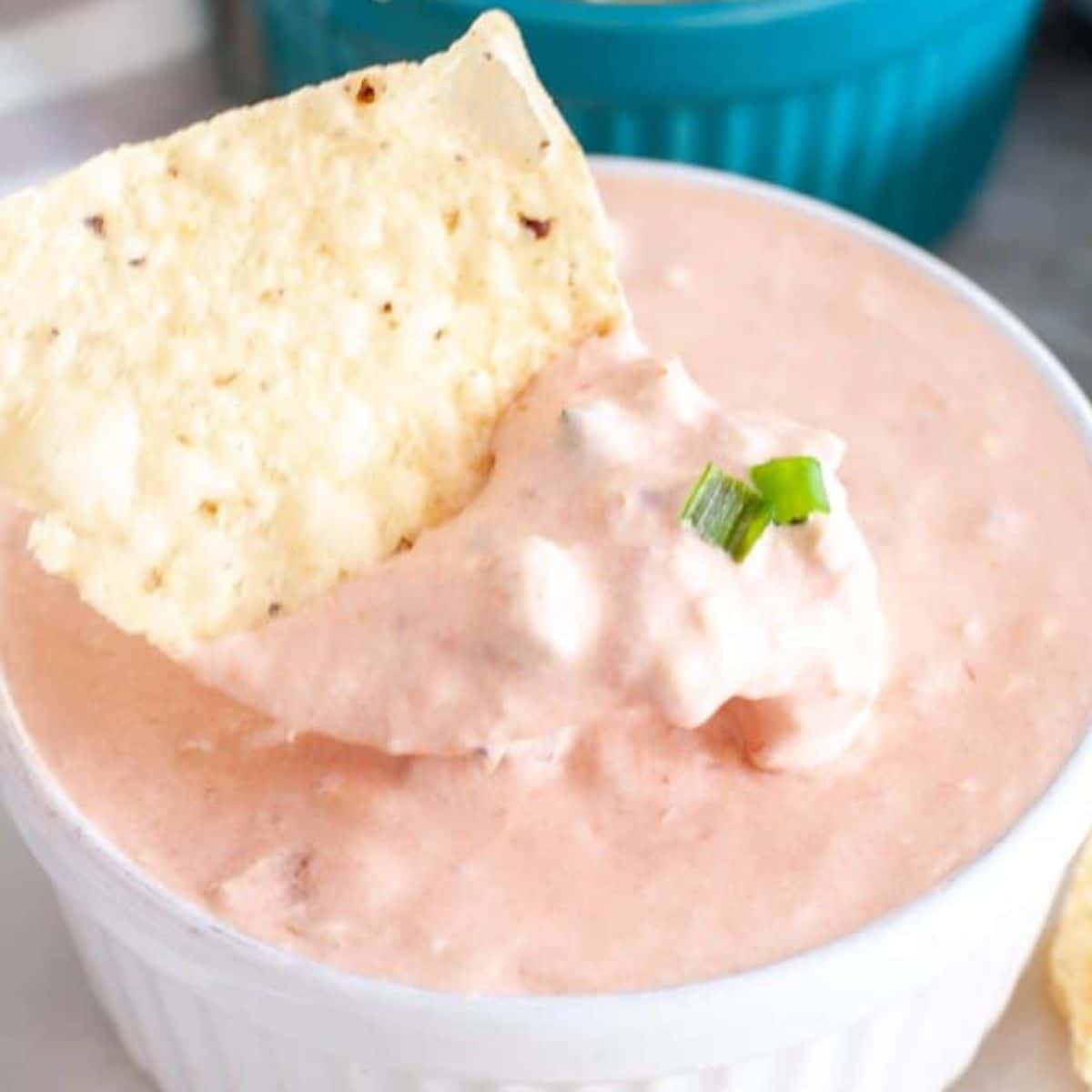 Bowl of cream cheese salsa dip with a tortilla chip.