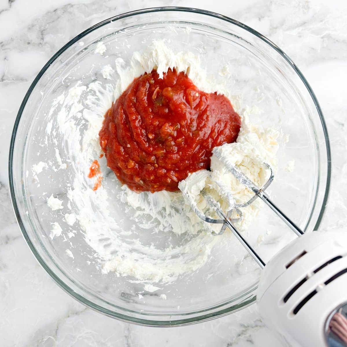 Bowl of cream cheese, salsa, and a mixer.