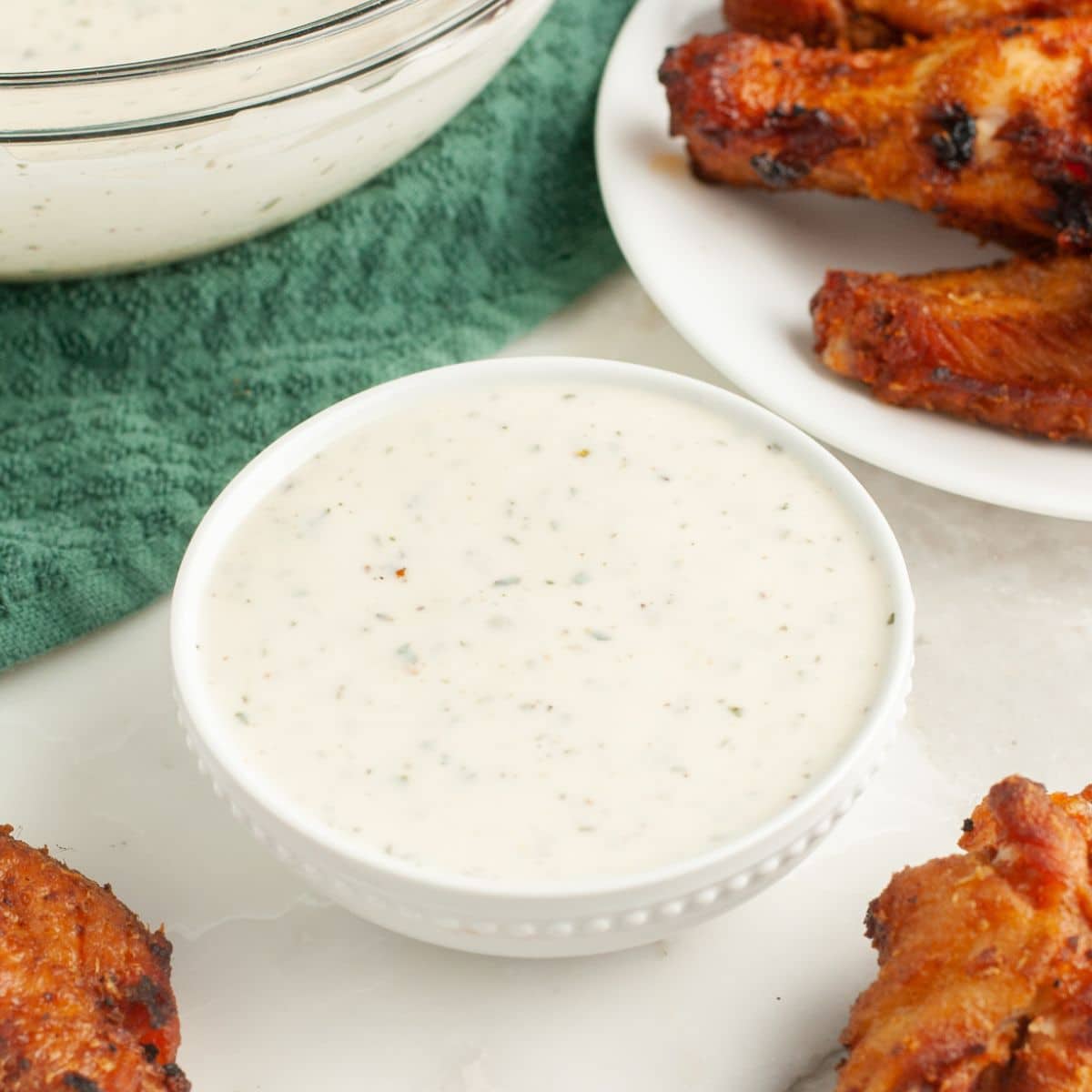 Bowl of ranch dressing with chicken wings. 