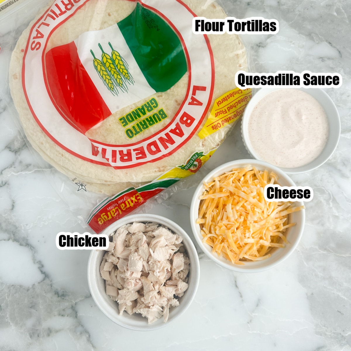 Tortillas, bowl of diced chicken, shredded cheese, and sauce. 