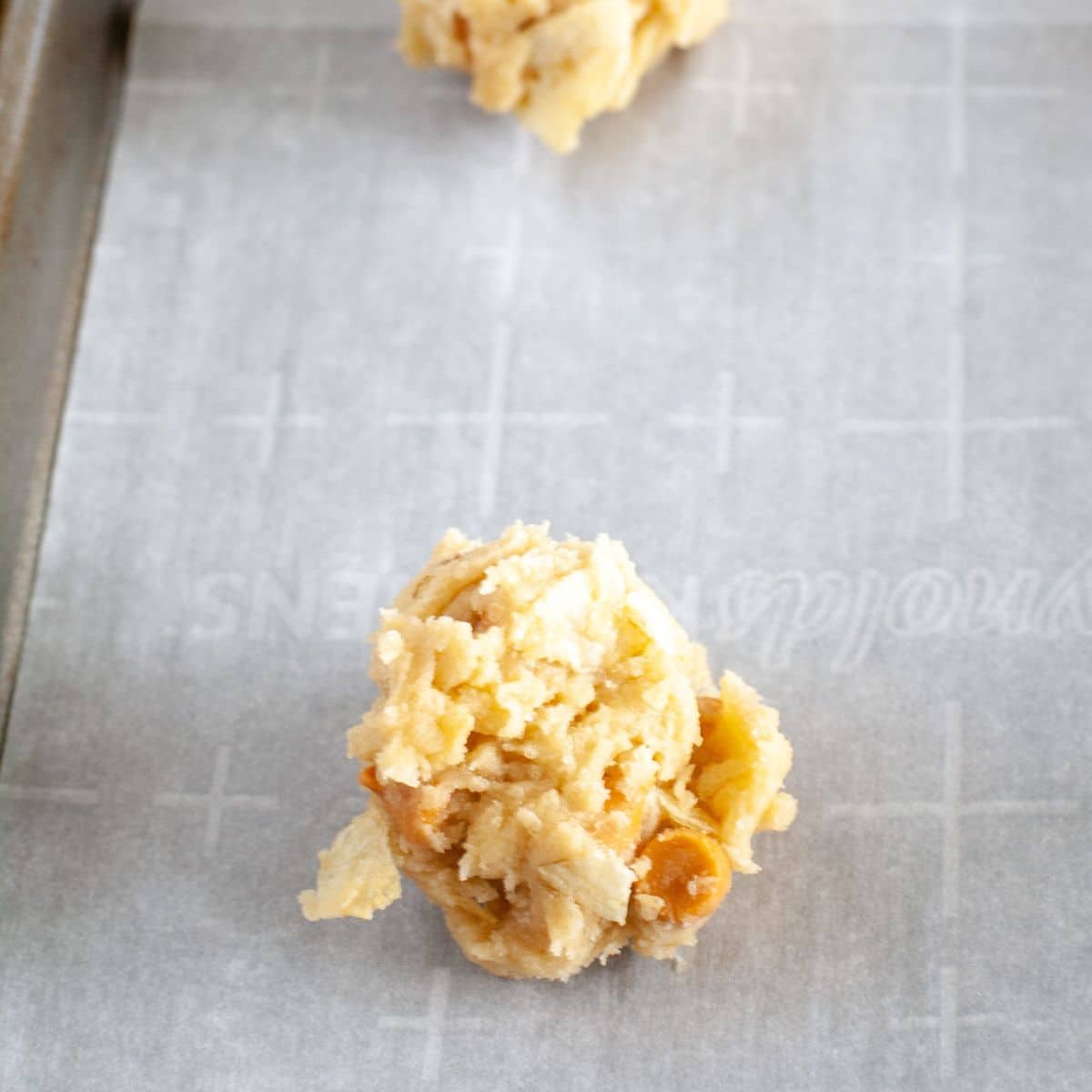 Ball of cookie dough on a baking pan. 