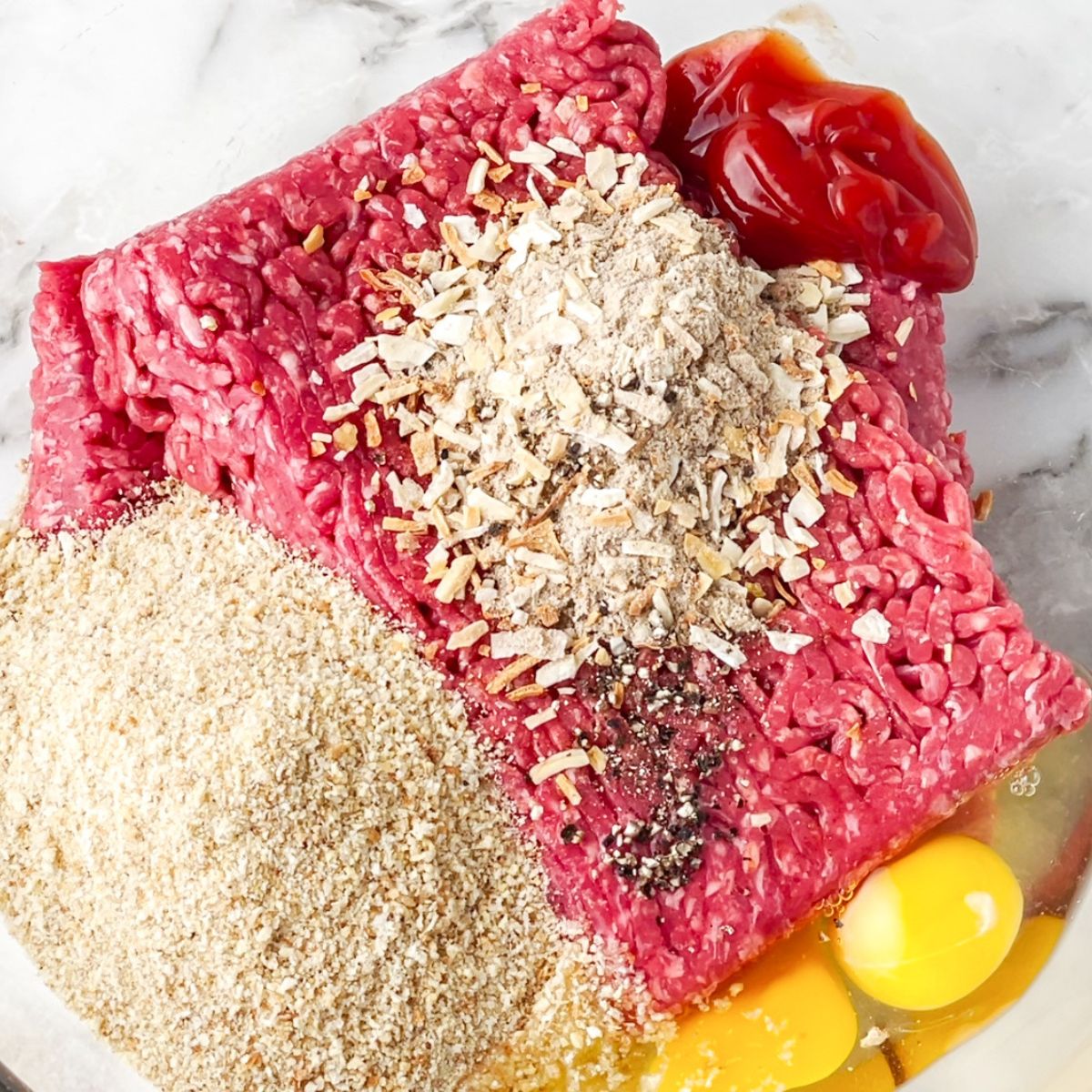 Bowl of ground beef, onion soup mix, bread crumbs, and eggs. 