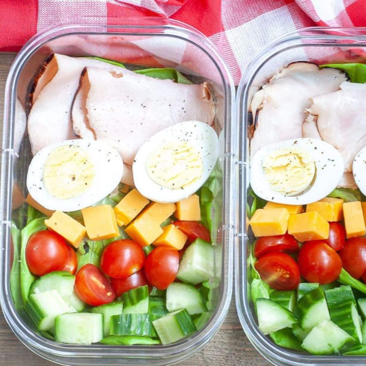 Turkey, hard boiled eggs, and vegetables in a container.