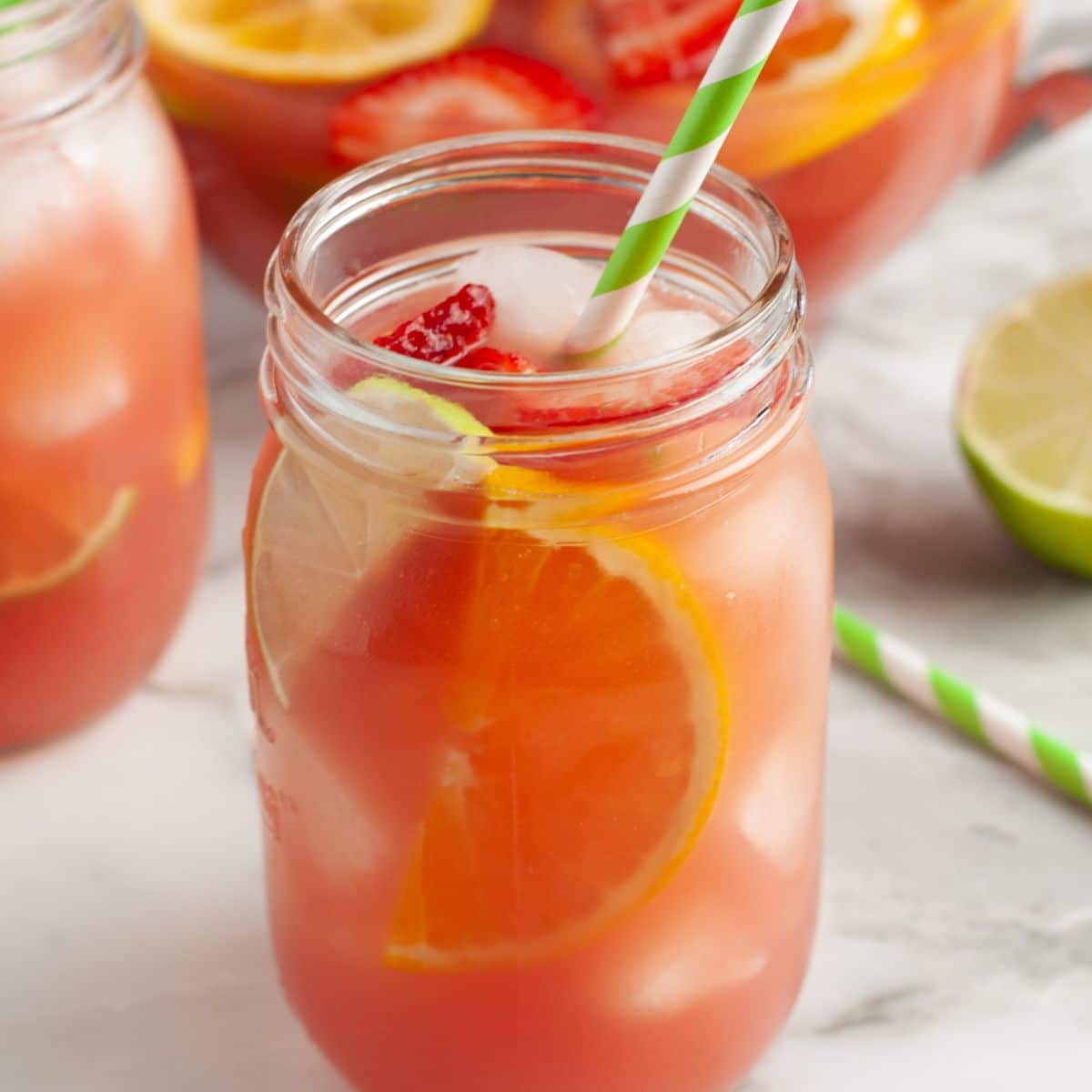 Glass of fruit punch with green straw.