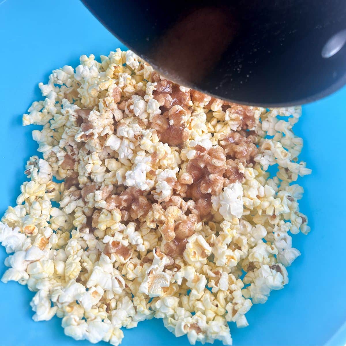 Bowl with popcorn and cinnamon butter mixture.