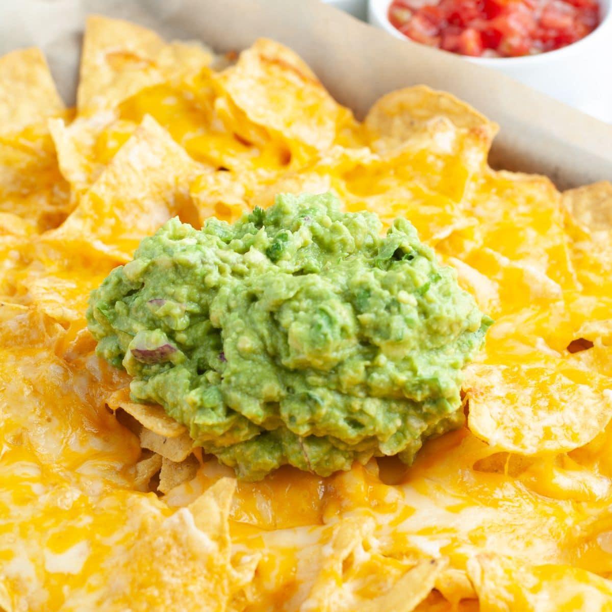 Tortilla chips topped with melted cheese and guacamole. 