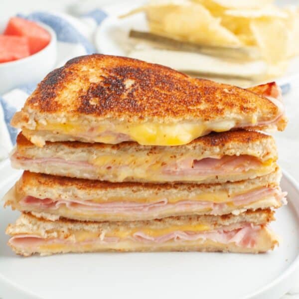 Stack of grilled ham and cheese sandwiches.