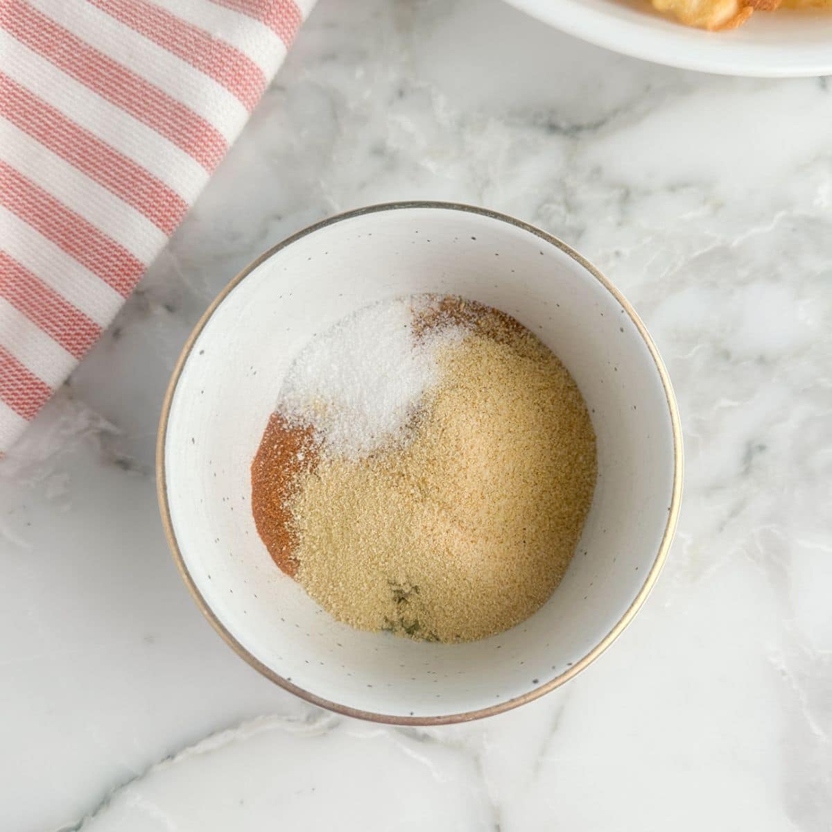 Bowl of garlic powder, salt, and paprika. 