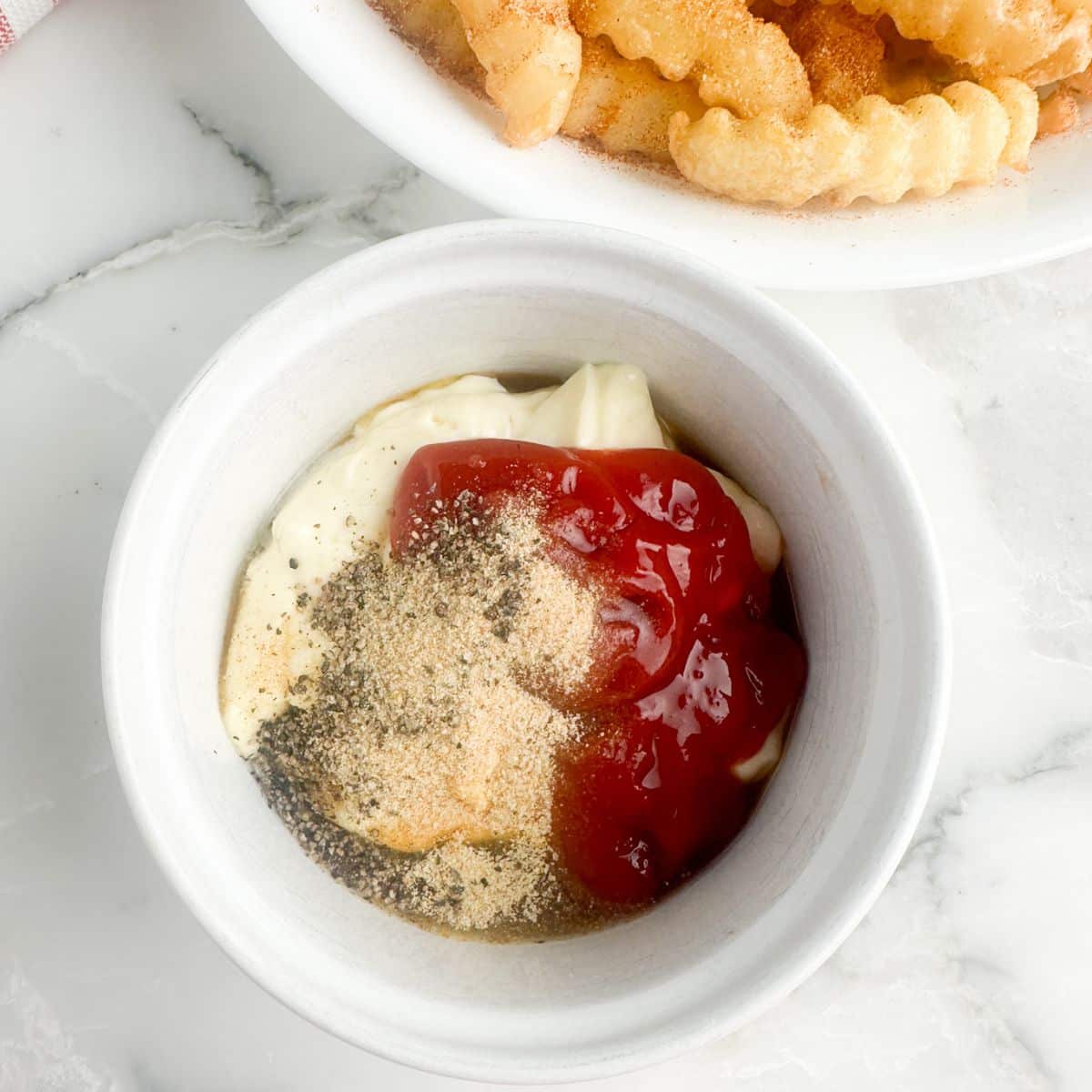 Bowl of mayonnaise, ketchup, and seasonings. 