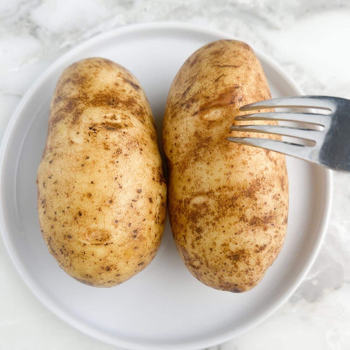 Fork piercing potatoes.