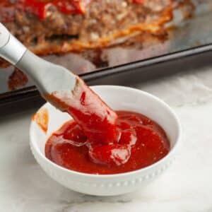 Bowl with ketchup and a brush.