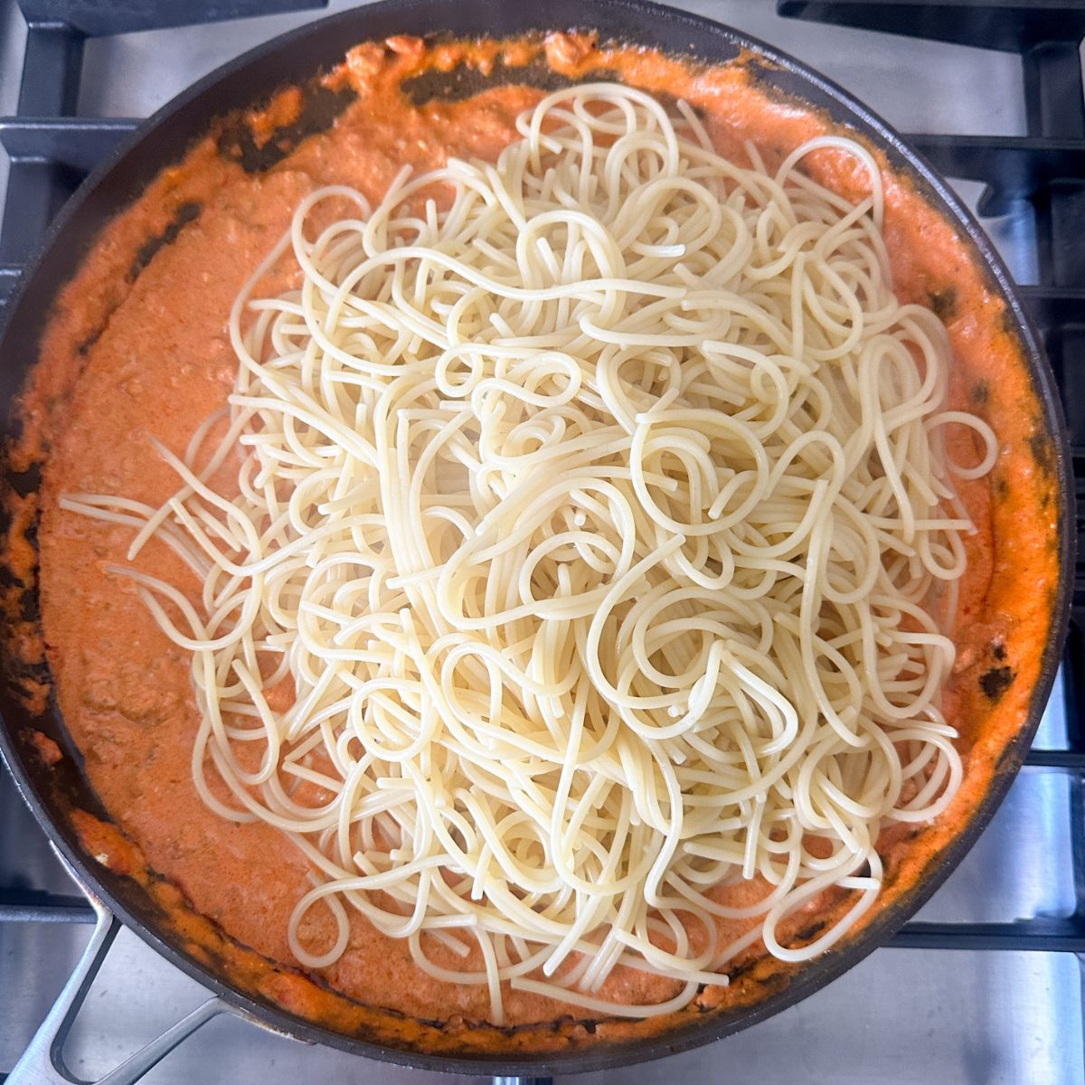 Skillet with creamy marinara sauce and spaghetti.