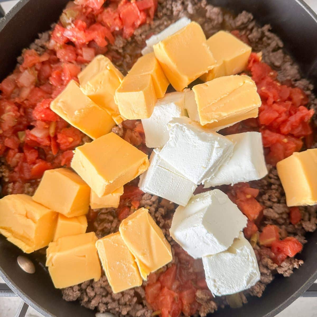 Ground beef with diced tomatoes, cubed Velveeta, and cream cheese.