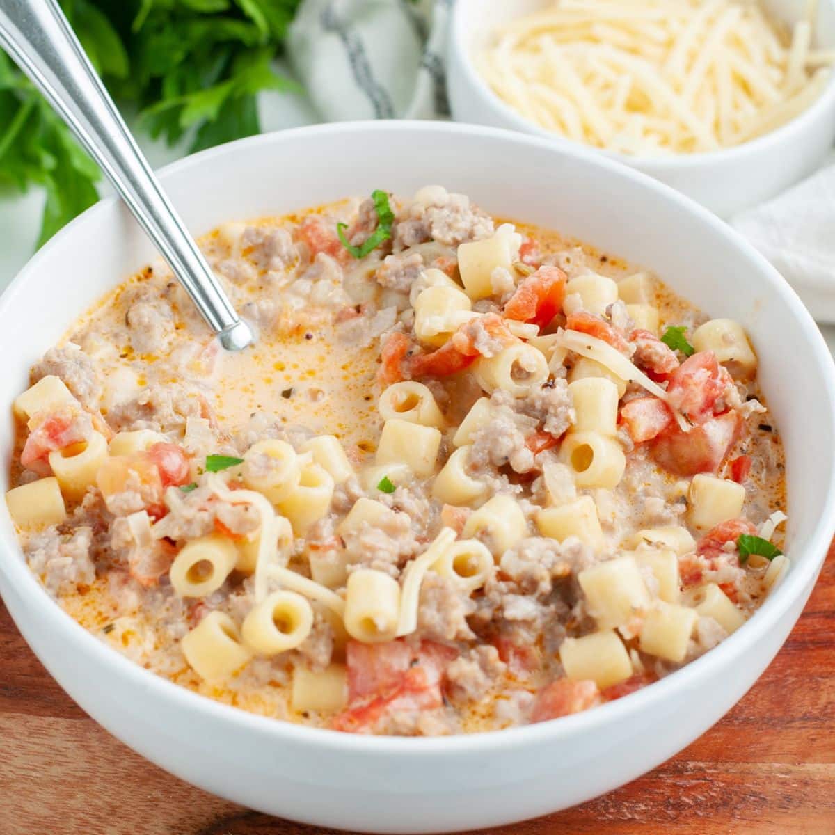 Bowl of creamy soup with pasta and sausage. 