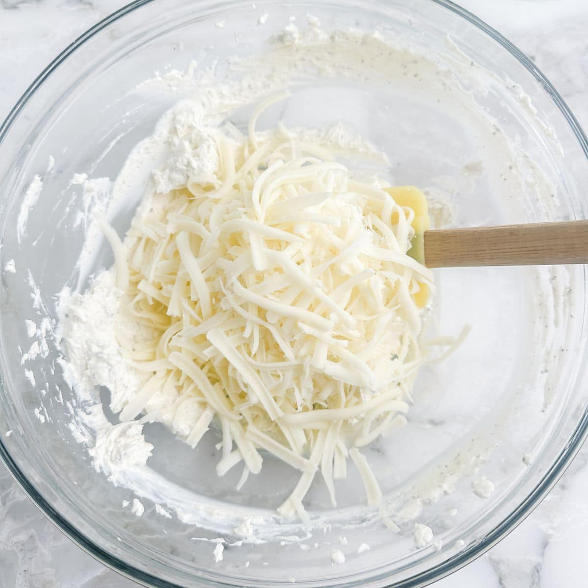 Bowl of cream cheese and shredded mozzarella.